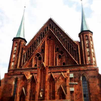large brown brick church with lots of windows and tall roof